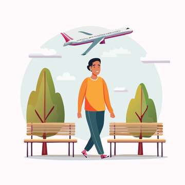 Man walking in park with airplane overhead