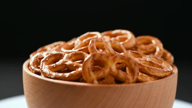 Rotating bowl of pretzels on table close up snack food concept
