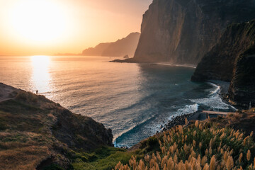 Panoramic view of massive ocean cliffs and coastline in golden sunrise light. © Jan