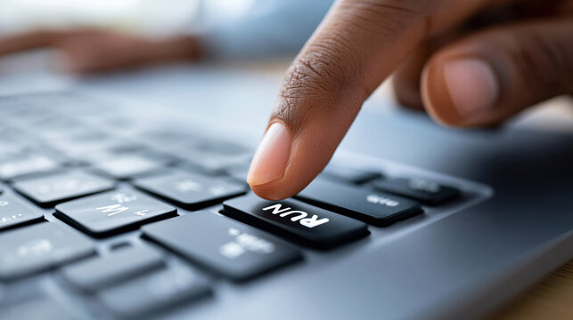 Close-up of a hand pressing a RUN button on a keyboard in minimalist close-up conveying action and process start, automation trigger concept, run button photography, process