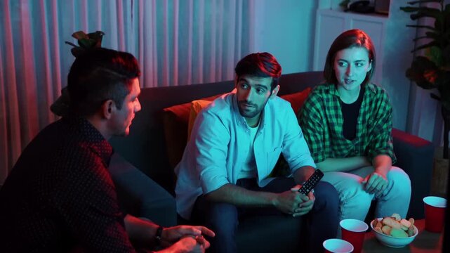 Caucasian father and mother talking with colleague while pick up snack bowl to friend. Happy family sitting at seat in living room while enjoy watching movie with caucasian man at home. Convocation.