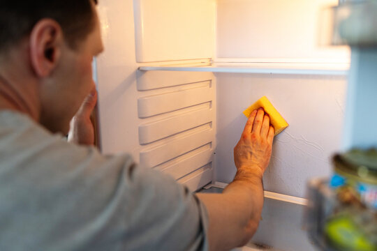 Cleaning inside a refrigerator using cloth for hygiene and organization. closeup of technician meticulously cleaning and sanitizing refrigerator surfaces and compartments.