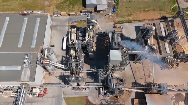 Aerial shot of a manufacturing facility with smoking chimney during production	