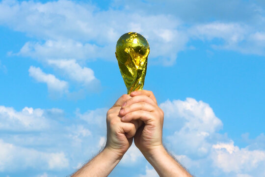 Moscow, Russia - May 22, 2026: FIFA World Cup Trophy in male hands сelebrating the victory against blue sky with clouds