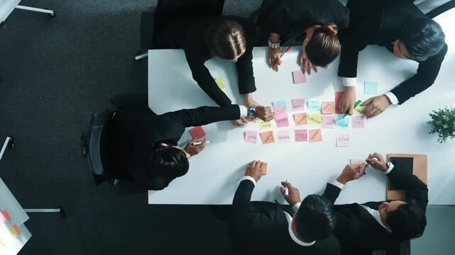 Top view of smart business team planning marketing strategy at meeting room. Professional executive manager exchange data and brainstorm idea while writing in sticky notes at workplace. Directorate.