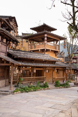 Obraz premium Wangxian Valley, china - Traditional Chinese wooden architecture with tiled roofs, hanging lanterns, and carved balconies in an ancient village courtyard.