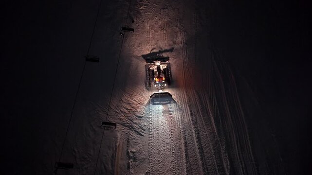 Snow Machine Shaping Ski Slopes. Drone Captures Snow Groomer Contouring Slope For Skiing Preparation