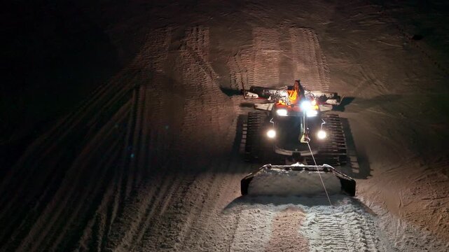 Lights Brighten Path. Strong Headlights Pierce Darkness While Grooming Equipment Ascends Steep Trail Carefully