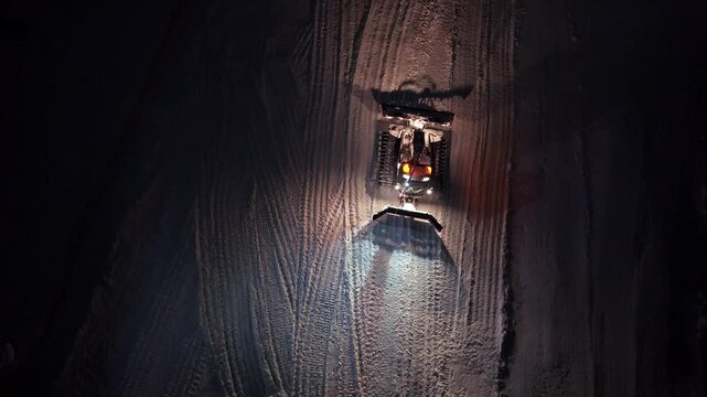 Isolation Of Snow Grooming Machine In Quiet Winter Night Displaying Parallel Paths And Textured Surface