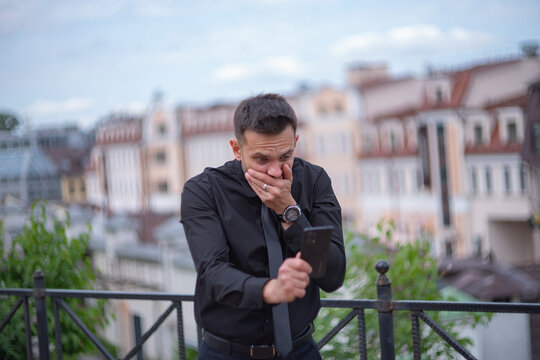 Shocked businessman covering mouth in fear looking at phone with copy space