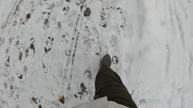 This image captures a close-up view of footprints in freshly fallen snow, highlighting the intricate patterns left by footsteps. The serene winter landscape evokes feelings of peace and tranquility.