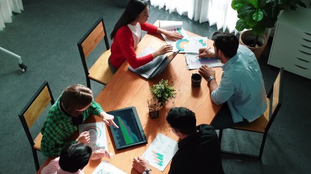 Top view of project manager present financial graph to investors at meeting. Professional marketing team brainstorming financial idea while looking at financial statistic from laptop. Convocation.