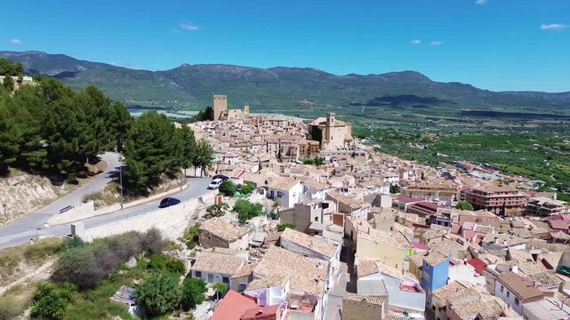 Aerial drone view of historic Calasparra town in southern Spain featuring old town houses medieval castle mountain landscape traditional architecture travel destination and scenic urban panorama under