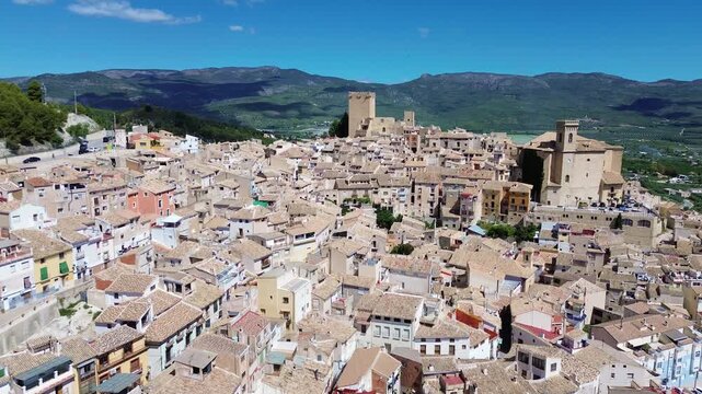 Aerial drone view of historic Calasparra town in southern Spain featuring old town houses medieval castle mountain landscape traditional architecture travel destination and scenic urban panorama under