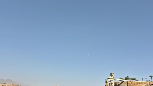 a plane is flying far away in the blue sky