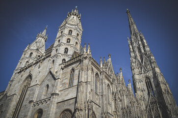Fototapeta premium Iconic view of St. Stephen’s Cathedral rising above the historic center of Vienna, Austria. This famous Gothic landmark captures the city's rich heritage, dramatic architecture and timeless culture.