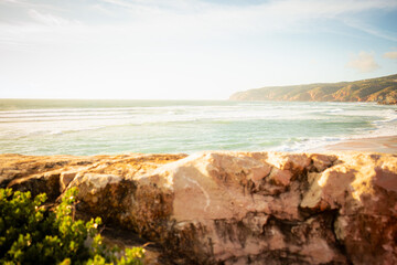 Beautiful sunset over the Atlantic Ocean waves with a scenic coastline and distant hills. Peaceful seascape capturing the natural beauty of the coast during golden hour. © Vaidile