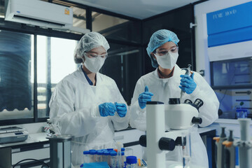 Researchers wearing protective equipment performing experiments and analyzing samples with a...