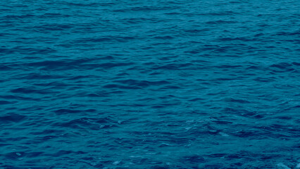 Obraz premium Deep blue sea water with soft ripples and waves.