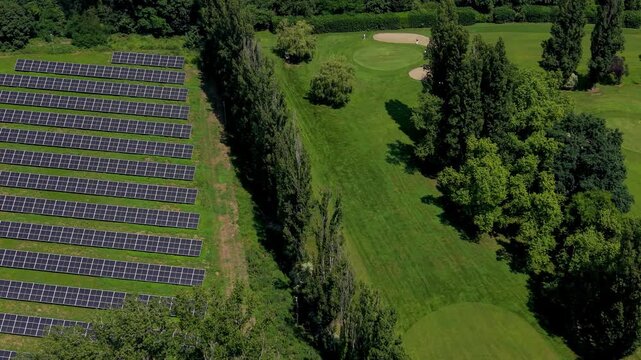 Solar Farm Next to Golf Course: An aerial view showcases a modern solar farm with rows of photovoltaic panels situated beside a manicured golf course.