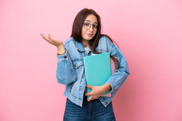 Fototapeta premium Young Ukrainian student woman isolated on pink background having doubts while raising hands