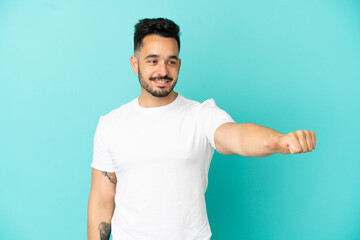 Fototapeta premium Young caucasian man isolated on blue background giving a thumbs up gesture