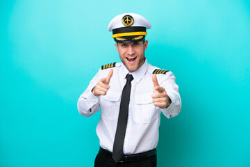 Airplane caucasian pilot isolated on blue background pointing to the front and smiling © luismolinero