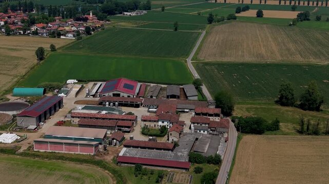 Rural Landscape: An expansive aerial view captures a sprawling farmstead nestled within a patchwork of agricultural fields, showcasing the harmonious blend of human endeavor and natural landscape.