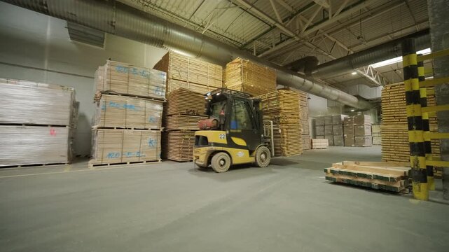 A large industrial warehouse featuring a forklift operating among stacks of dried wooden planks prepared for further furniture or flooring production