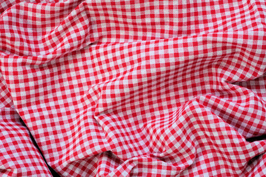 Red and white check table cloth background. Top view. Copy space. Summer outdoor food or picnic theme.
