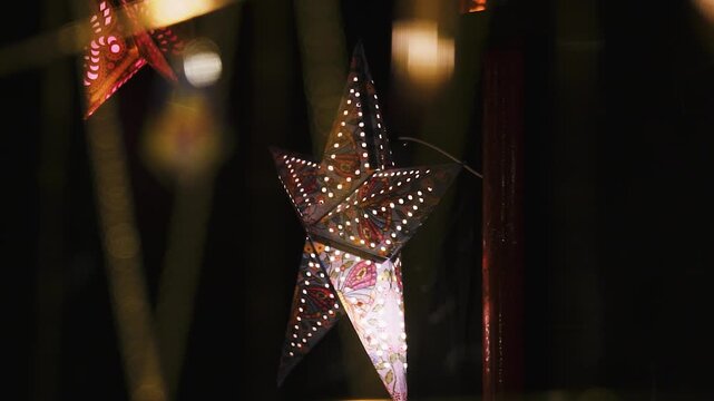 Goldene Schmuckketten vor beleuchtetem Weihnachtsstern auf Markt