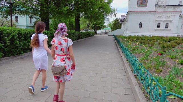 Slow Motion Two sisters are walking around the courtyard of the Borisoglebsky Kremlin in Dmitrov, Russia.