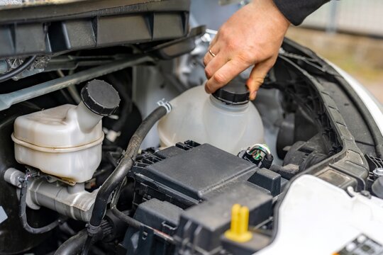 Refilling coolant to prevent engine overheating. Adding fluid to radiator for system safety. Engine cooling system is replenished with fluid to prevent overheating and maintain performance