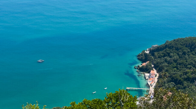Beautiful landscape. Top view to amazing Atlantic Ocean shore, near Setubal, Portugal. Wonderful bay with azure clear water and small stony island Anixa. Beach Portinho da Arrabida or Praia do Creiro.