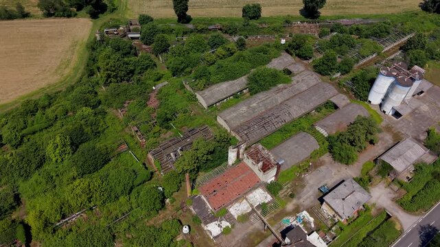Abandoned Industrial Complex: An aerial view reveals an overgrown and derelict industrial site, with decaying buildings and encroaching vegetation painting a picture of forgotten industry.