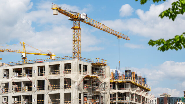 Construction crane towers over unfinished concrete buildings