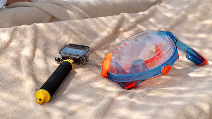 Bright snorkel and camera rest on soft sand © I