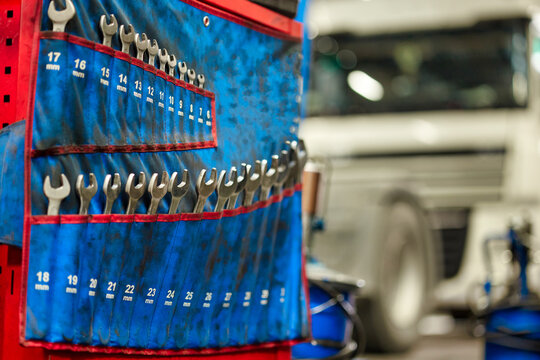 A visually striking collection of various wrenches is displayed in a truck repair service workshop. Ideal for illustrating the tools mechanics use in their daily tasks.
