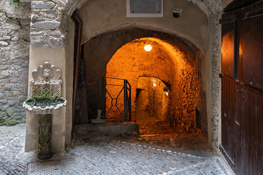 The narrow cobblestone alleys, archways and tunnels in the medieval old town Terra district underneath the hilltop castle of Dolceacqua, Italy, in the Ligurian region of Northern Italy. 