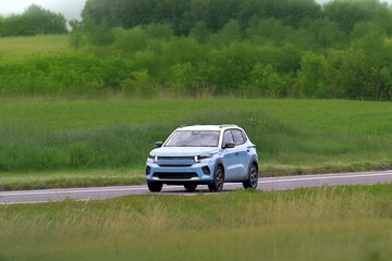 Fototapeta premium Crossover vehicle driving on empty country road