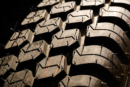 Studded tire tread highlighting deep lugs, rugged rubber texture and an aggressive pattern designed for off-road traction and reliable grip on icy, muddy or rough surfaces.