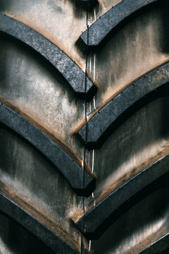 Massive black tractor tire tread with deep, aggressive grooves and rugged rubber texture.