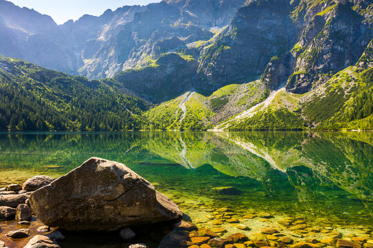 landscape with lake in mountains. scenic nature of poland with rocky summit reflection on the lake surface in summer. view of wonderful place in high tatra mountains for travel in eastern europe