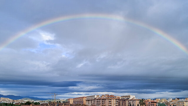Rainbow over the cityscape of Puerto de Sagunto after a storm in Valencia, Spain.