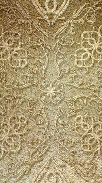 Antique metal surface with intricate ornamental pattern slowly transforming into a brilliant shining gold texture with luxurious lighting effects and metallic reflection