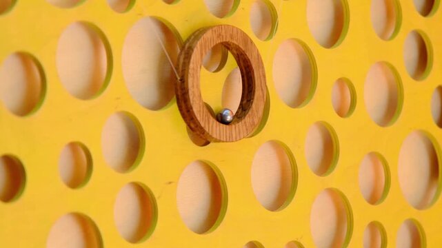 A children's educational board game featuring mice and cheese on a vertical wooden board with a metal ball in a ring. Board games. Horizontal video