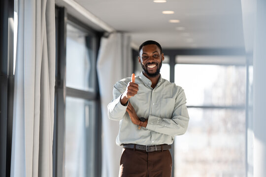 Happy businessman giving thumbs up showing approval