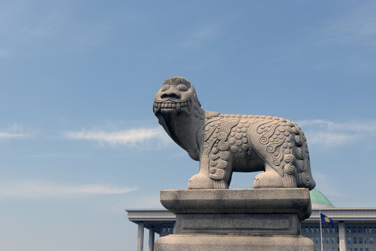 Traditional Korean Haechi stone statue with National Assembly building in Seoul, South Korea