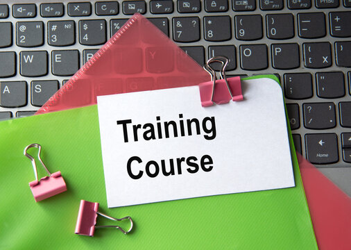 TRAINING COURSE - words on a white sheet on a laptop background with colorful folders