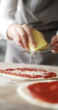 Close up of woman hands preparing pizza in kitchen
